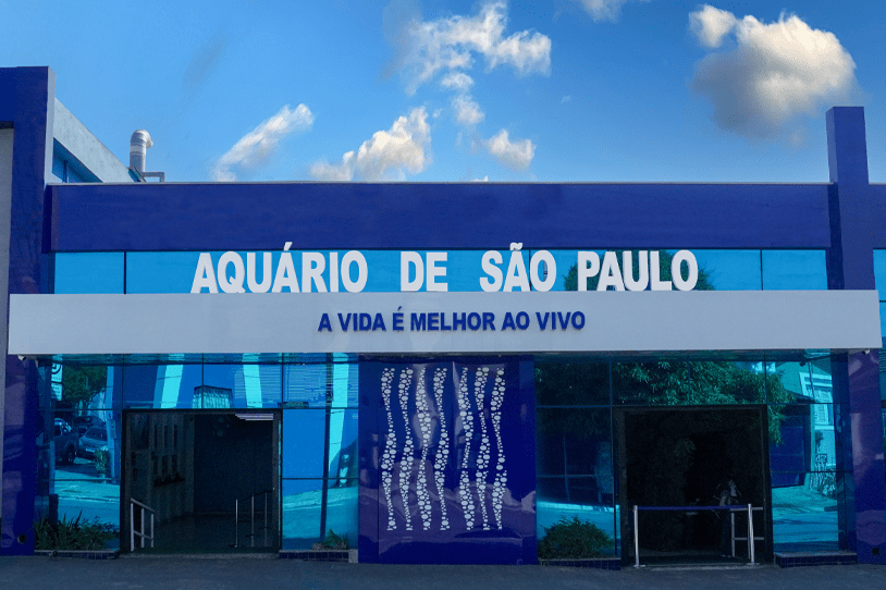 AquaRio Marinho do Rio de Janeiro - A large modern building with a blue facade and 'AquaRio' signage, showcasing the entrance to the aquarium with people walking nearby